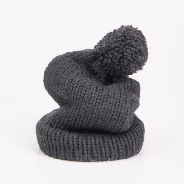 Bonnet uni noir avec pompon réalisé par Charlotte Tricote.