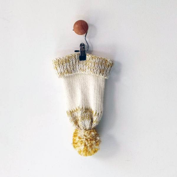 Bonnet avec pompon tricoté avec du fils blanc et or, idéal pour l'hiver. Design by Charlotte Tricote.