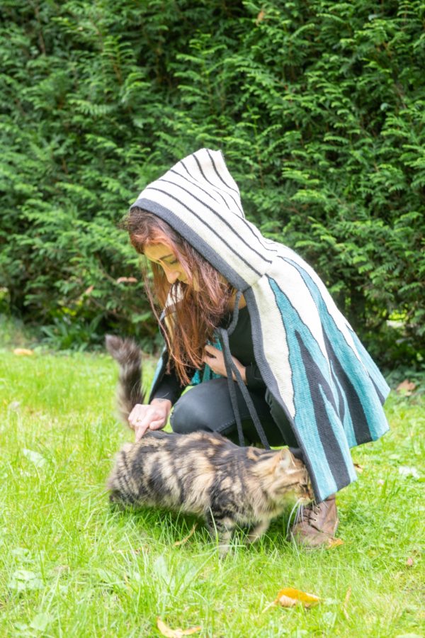 Cape avec capuche tricotée en laine de pays avec des motifs originaux.